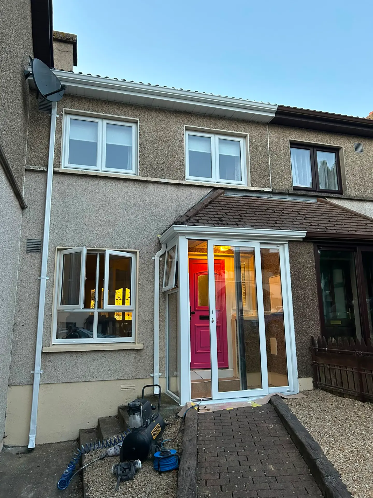 The same house with the porch and windows resprayed white and the door in pink